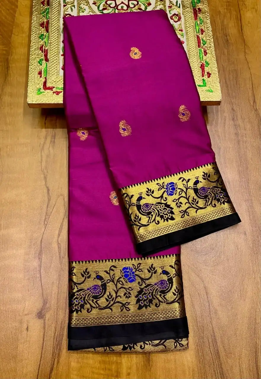 Magenta Paithani saree folded, black border woven with gold peacocks and creepers