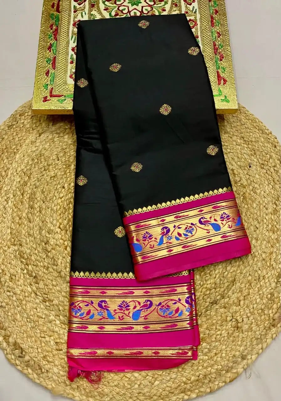 Black Paithani saree folded on a round jute mat, rani pink peacock border
