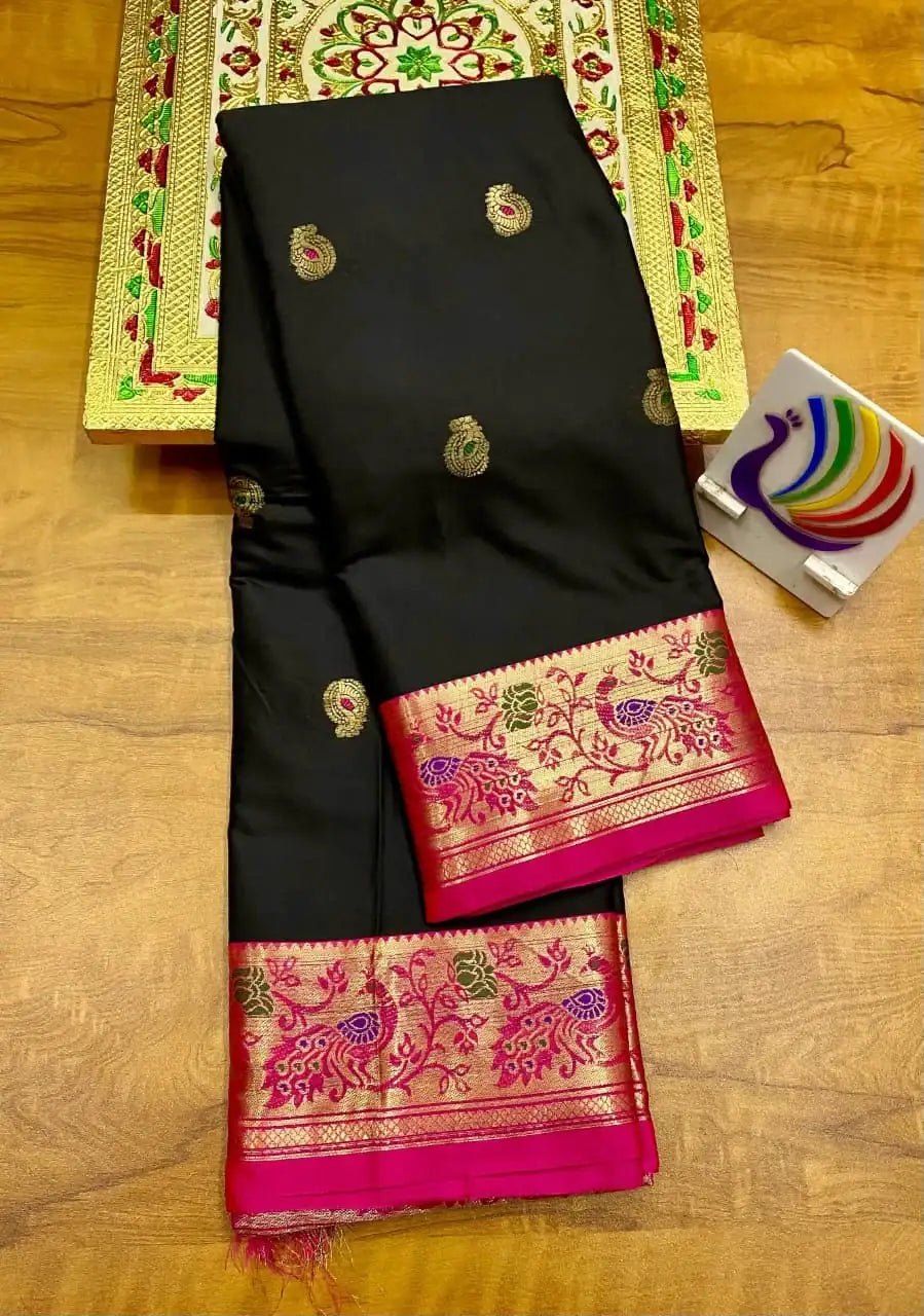 Black Paithani saree folded, rani pink border carrying gold peacock and floral brocade