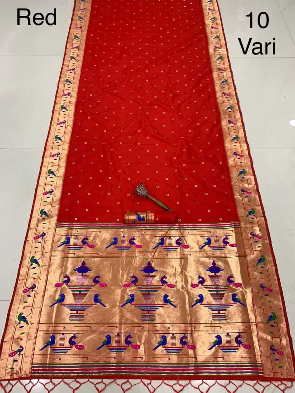Red nauvari saree laid out flat, gold tissue pallu woven with peacocks and vase motifs