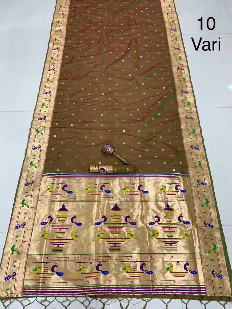 Brown saree spread on the floor, small zari bootis and a gold pallu of woven peacocks