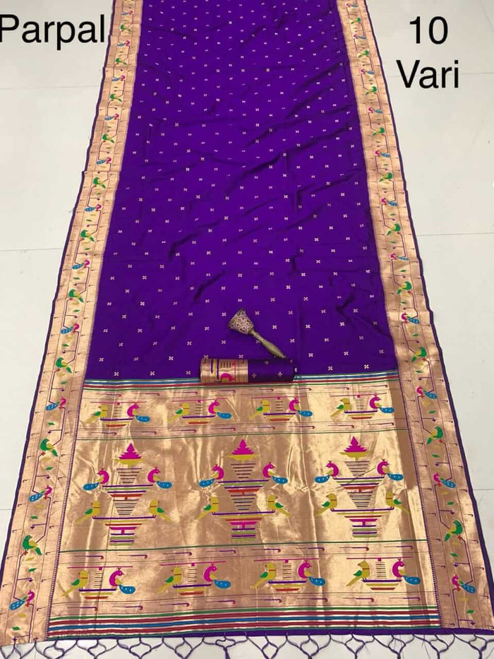 Purple saree laid flat with a rolled blouse piece, gold pallu of peacocks and flowerpots