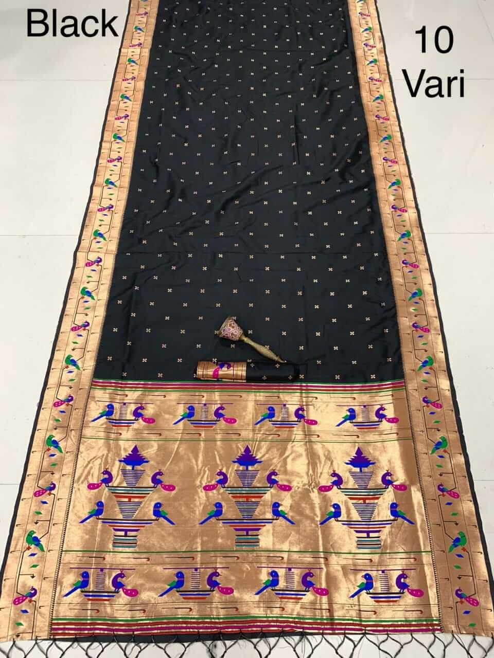 Black saree laid flat with zari bootis and a gold pallu of peacocks and vase motifs