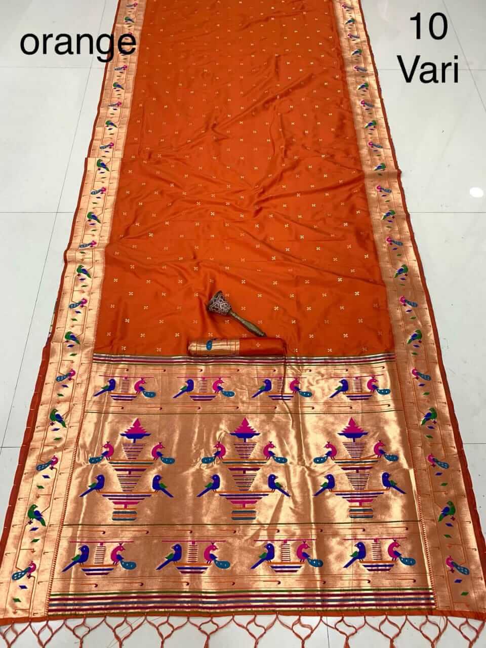 Orange saree spread out on the floor, broad gold tissue pallu with rows of woven peacocks