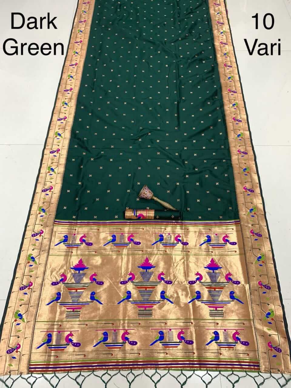Dark green saree laid flat with zari bootis, gold pallu carrying peacock and flowerpot motifs