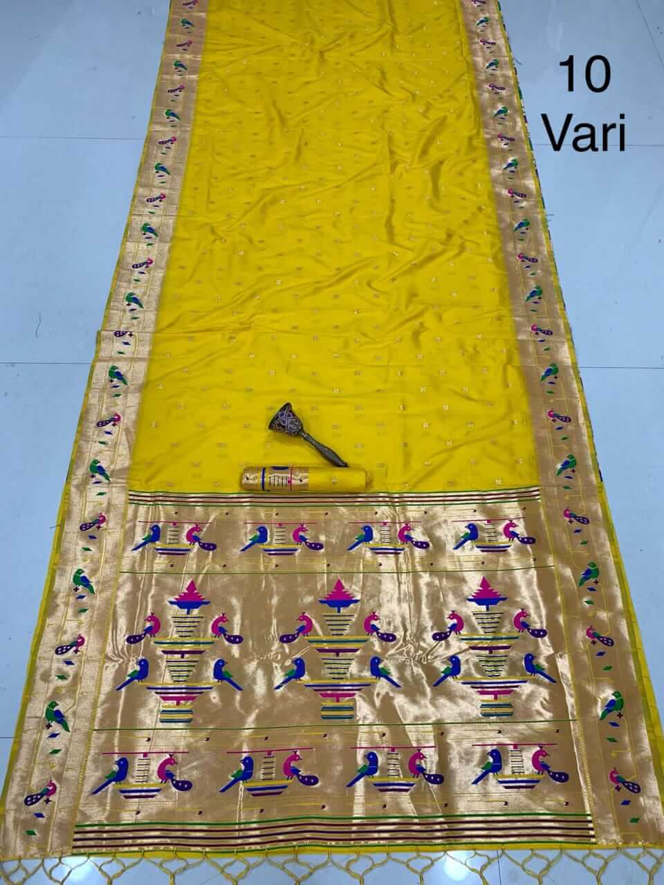 Yellow saree shown full length with rolled blouse piece and gold peacock-motif tissue pallu