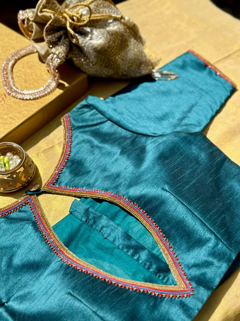 Teal blouse with a pointed keyhole back edged in pink and gold beads, angled