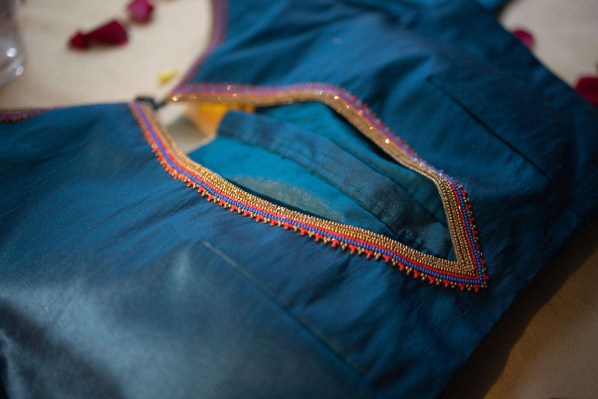 Close-up of the beaded trim outlining the blouse's leaf-shaped back opening