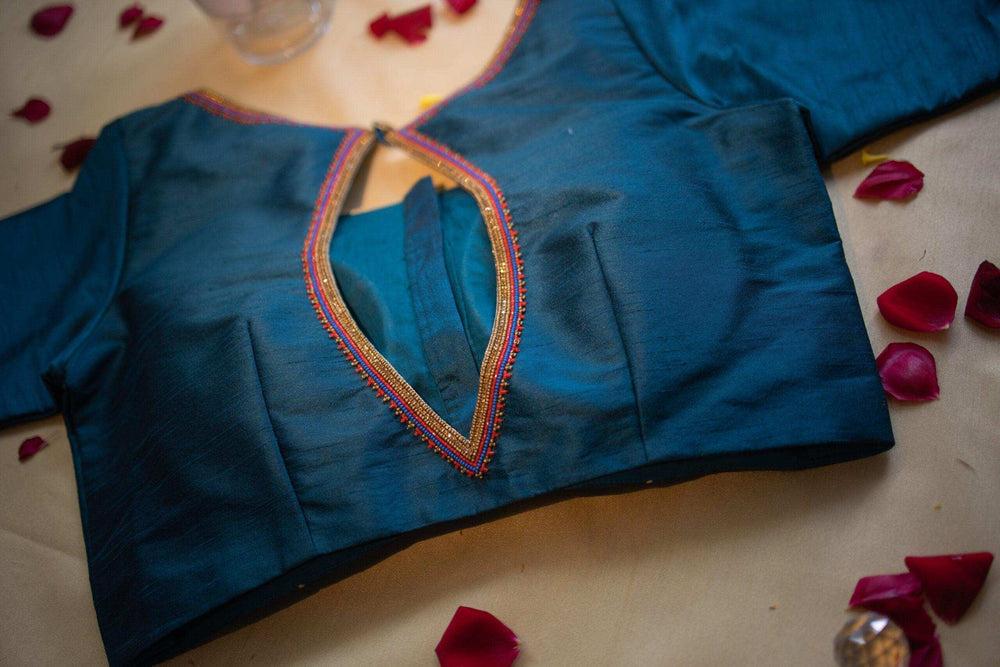 Back of the teal silk blouse with its beaded keyhole, rose petals scattered