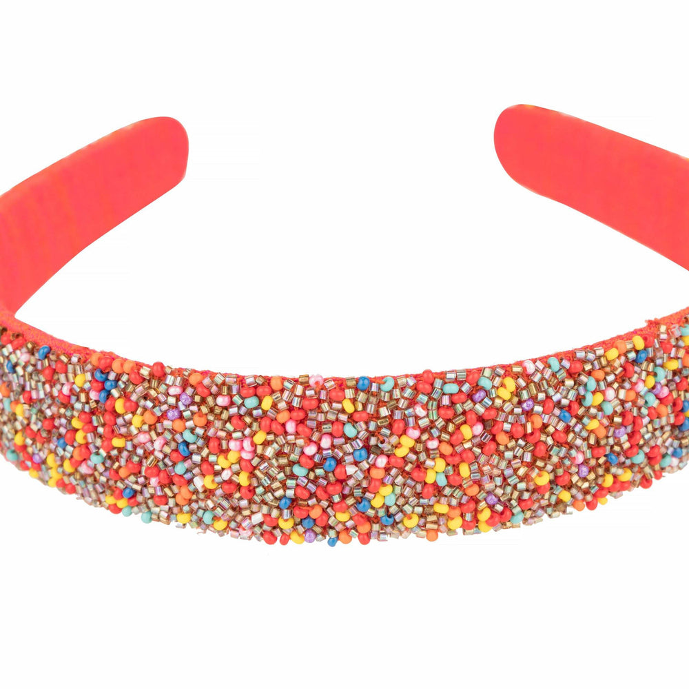 Close-up of the multicolour seed beads packed across the headband's coral padded band