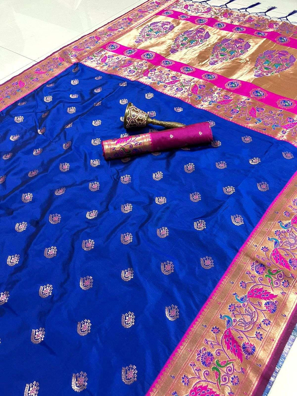 Royal blue body and rani pink peacock border on this flat-laid Paithani