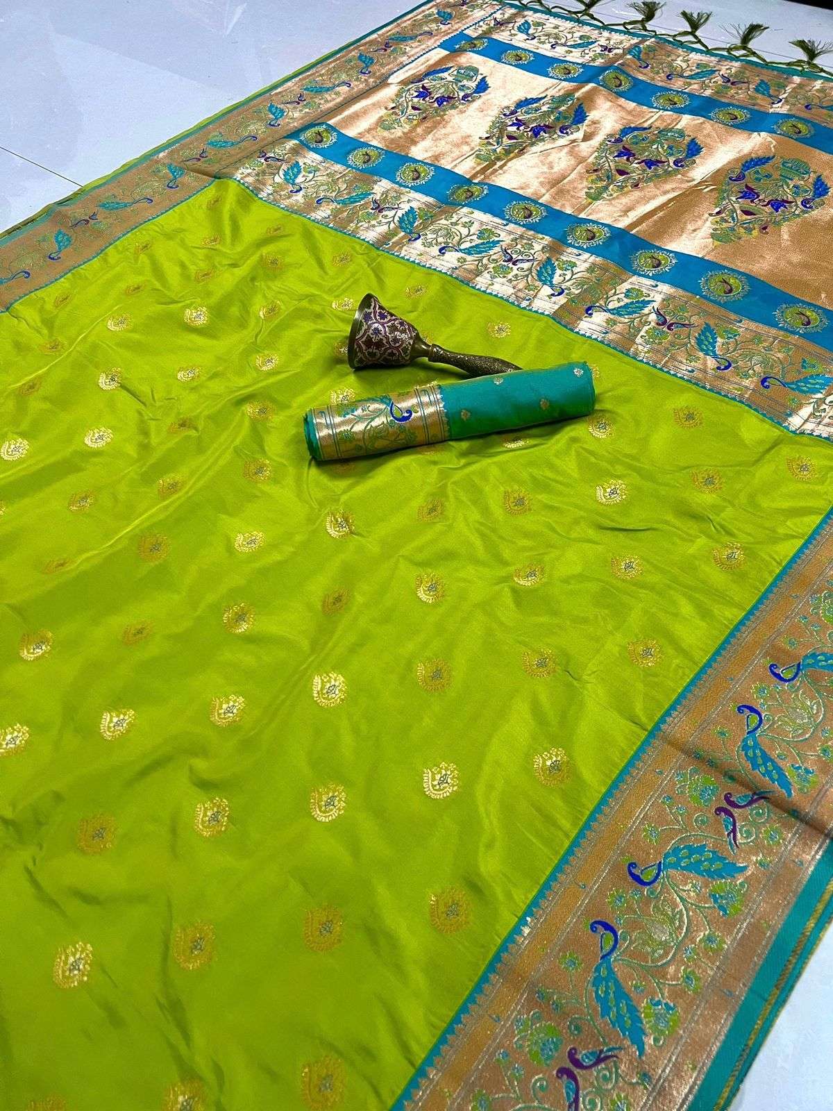 Parrot green Paithani saree with firozi blue peacock border, laid flat