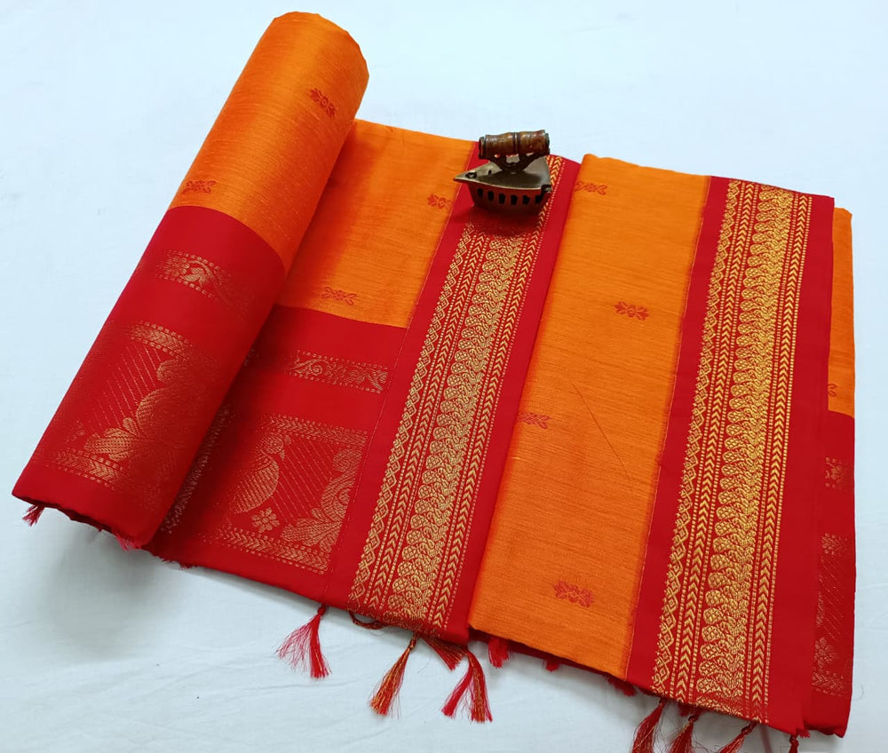 Bright orange saree with red zari border, folded flat with the pallu rolled to the left