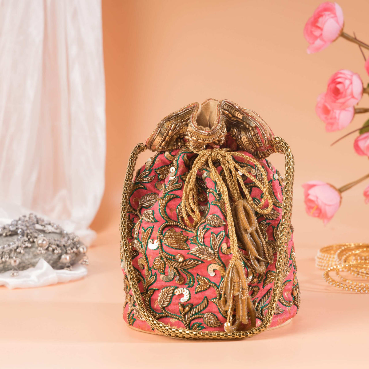 Drawstring top of the potli gathered shut with twisted gold cords and tassels