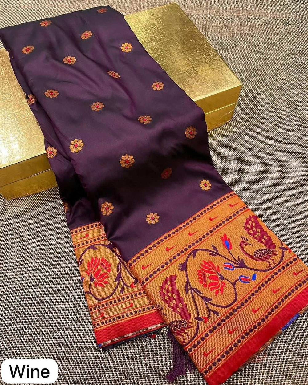 Wine shade body scattered with flower bootis above the woven peacock lotus border