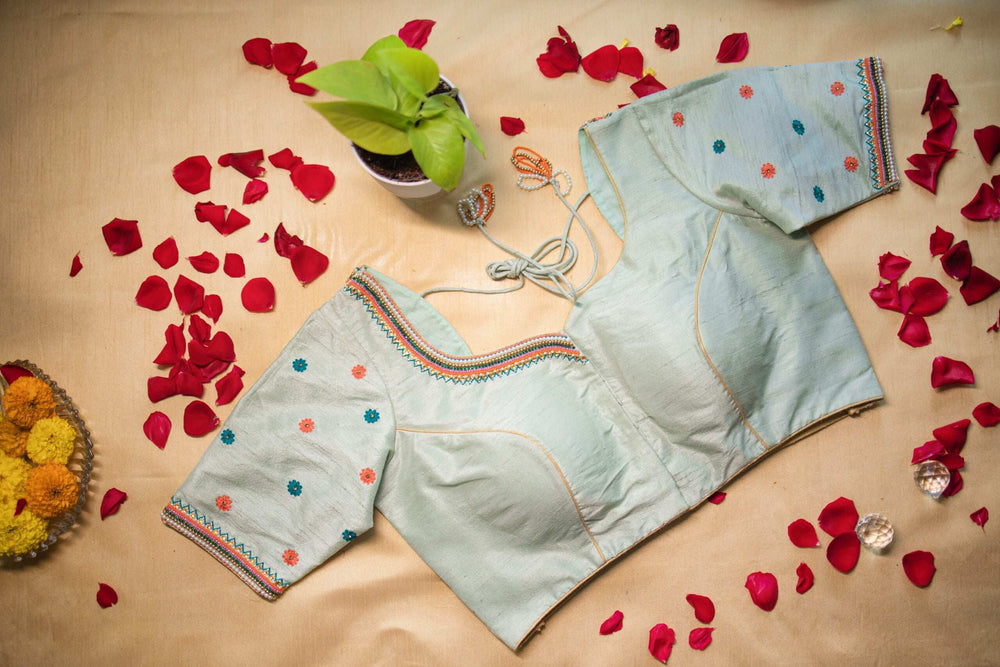 Pale mint blouse with orange and teal floral bootis, flat lay front view