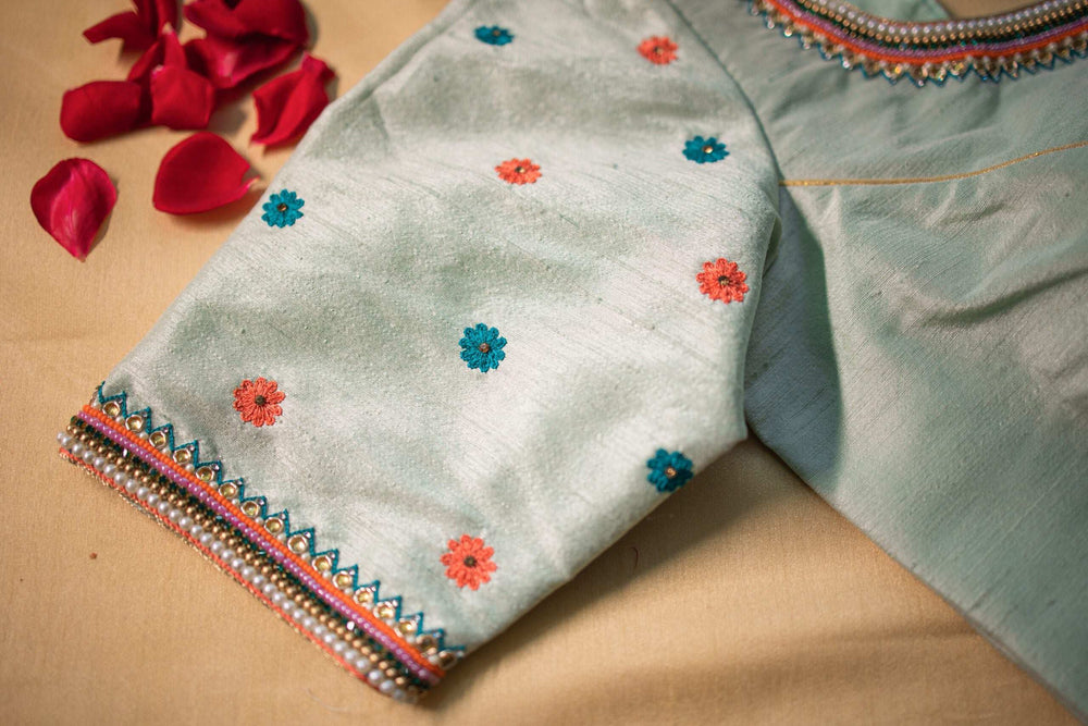 Sleeve detail with scattered floral bootis and a pearl-edged hem