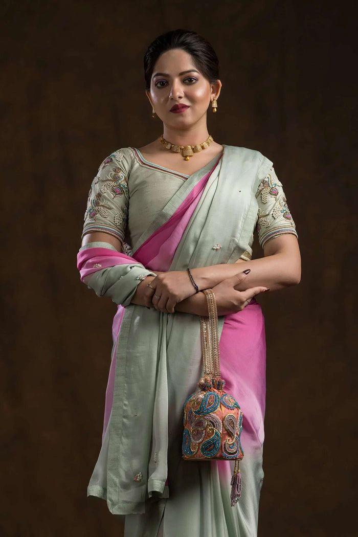 Model in the pistachio blouse and pink ombre saree, holding an embroidered potli