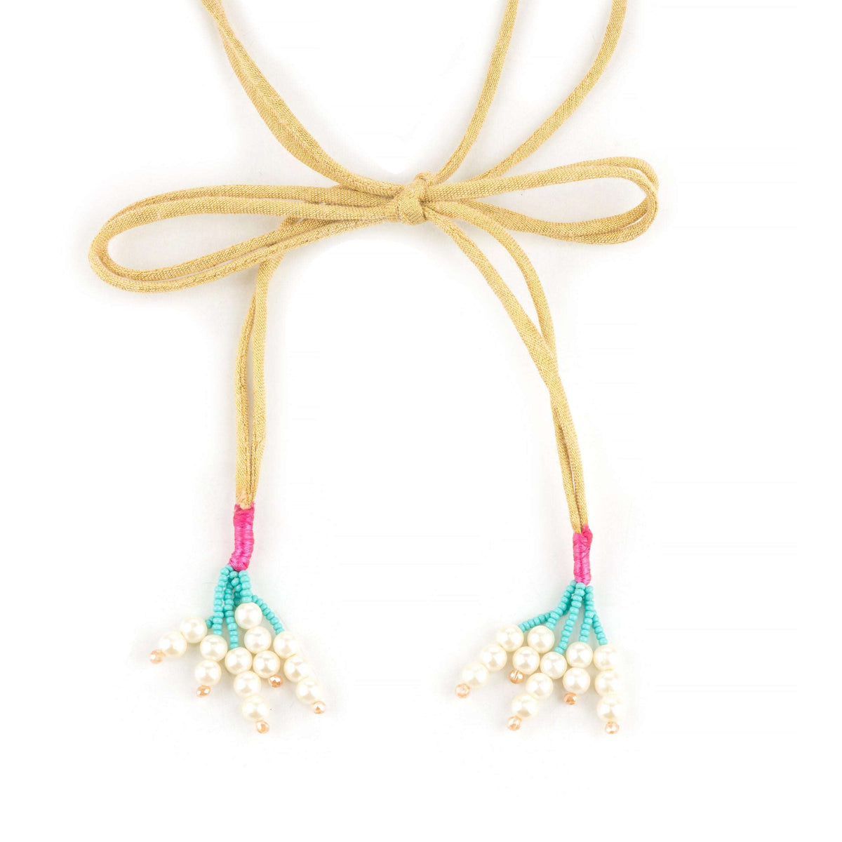 Suede tie cords knotted in a bow ending in pearl cluster tassels