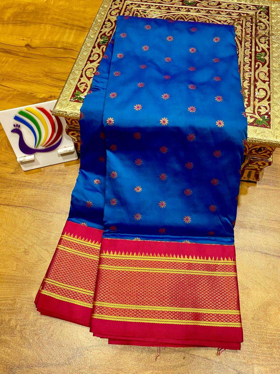 Blue kadiyal saree seen again from above, gold bootis over a red and gold woven border