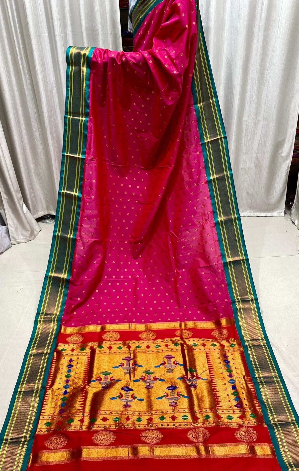 Rani pink drape with teal-green border and a gold pallu of woven motifs