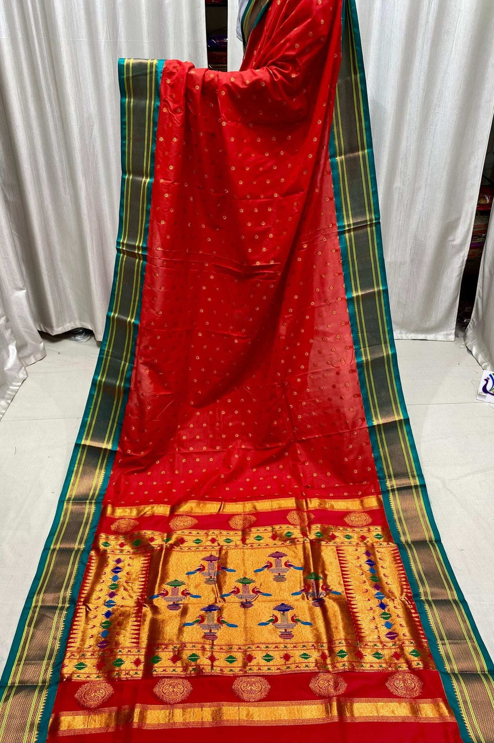 Red kadiyal saree hung in full length, green border and broad gold pallu