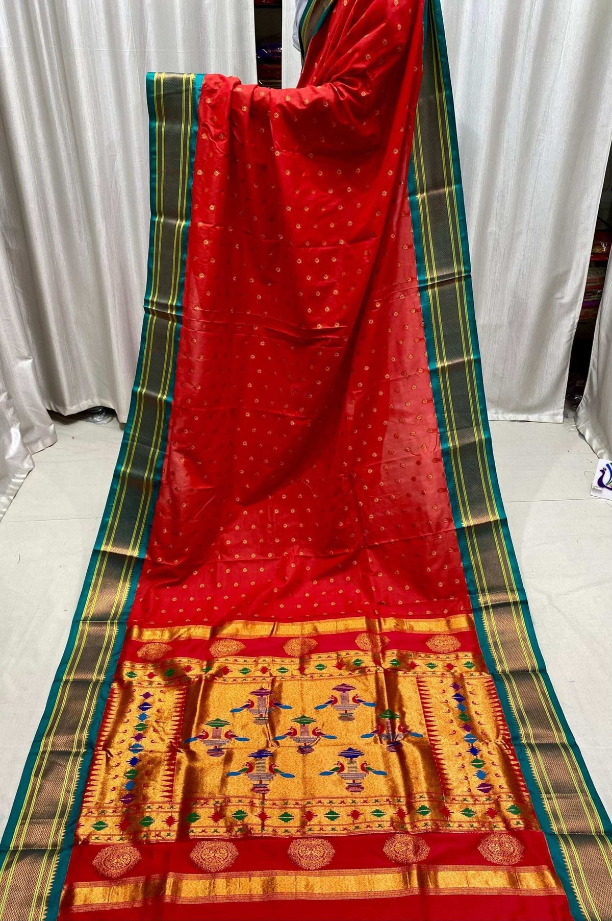 Red kadiyal saree hung in full length, green border and broad gold pallu