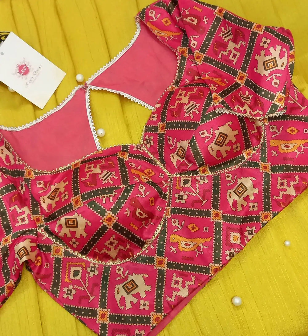 Grid of elephant, bird and dancer motifs across the pink patola blouse, laid flat