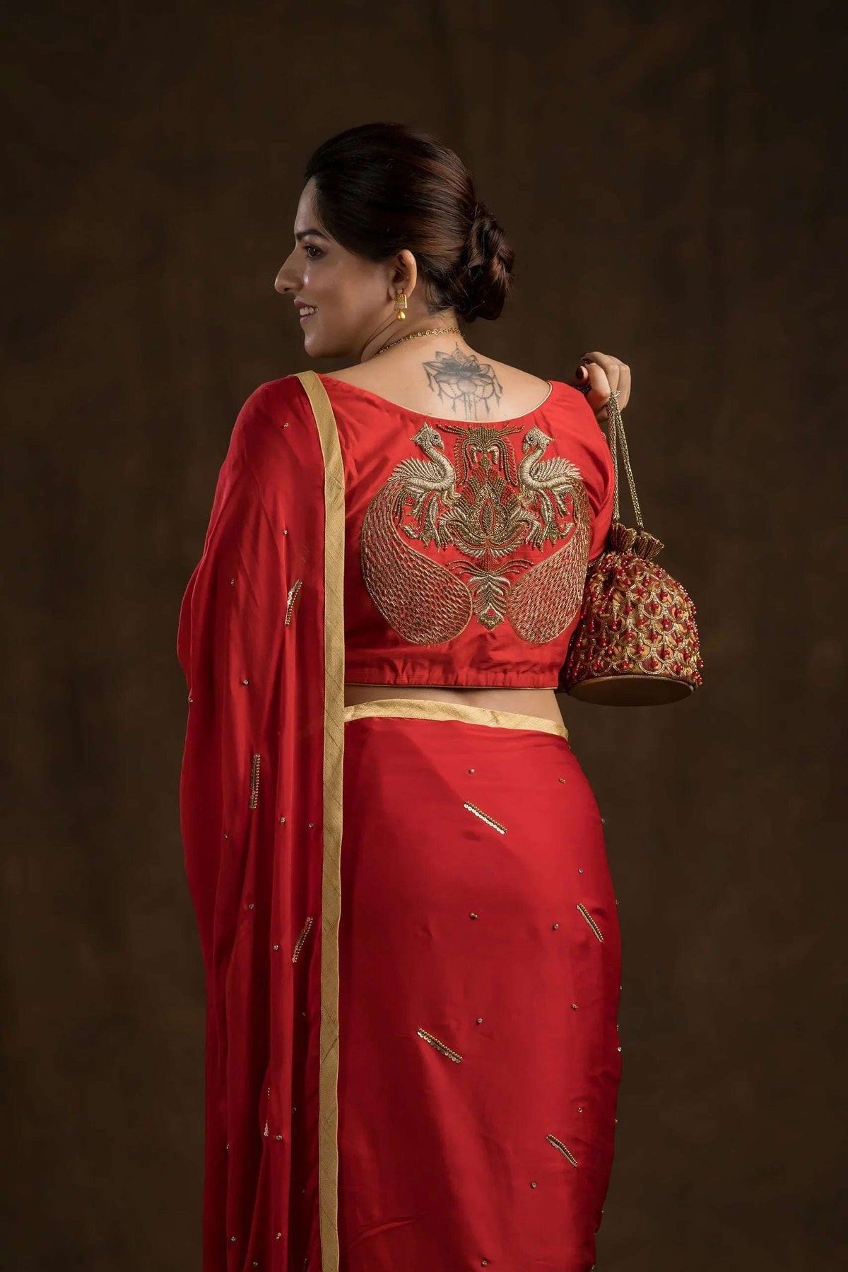 Twin peacock zardozi motif on the back of the red blouse, close-up
