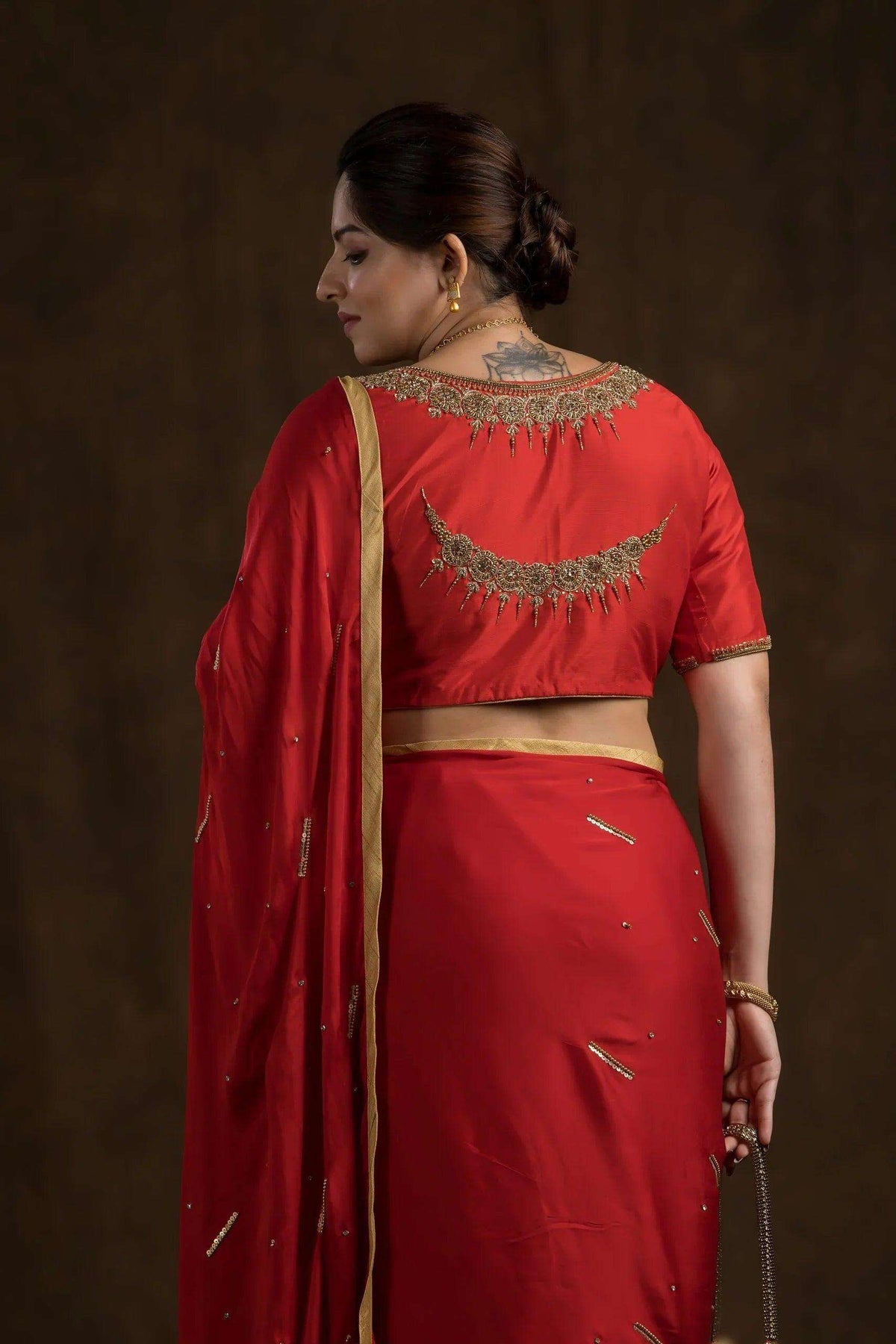 Crescent moon zardozi motif across the back of the red blouse, close-up