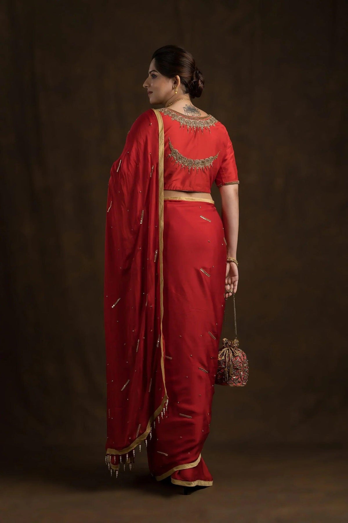 Full-length back view of the red saree drape with the embroidered blouse back