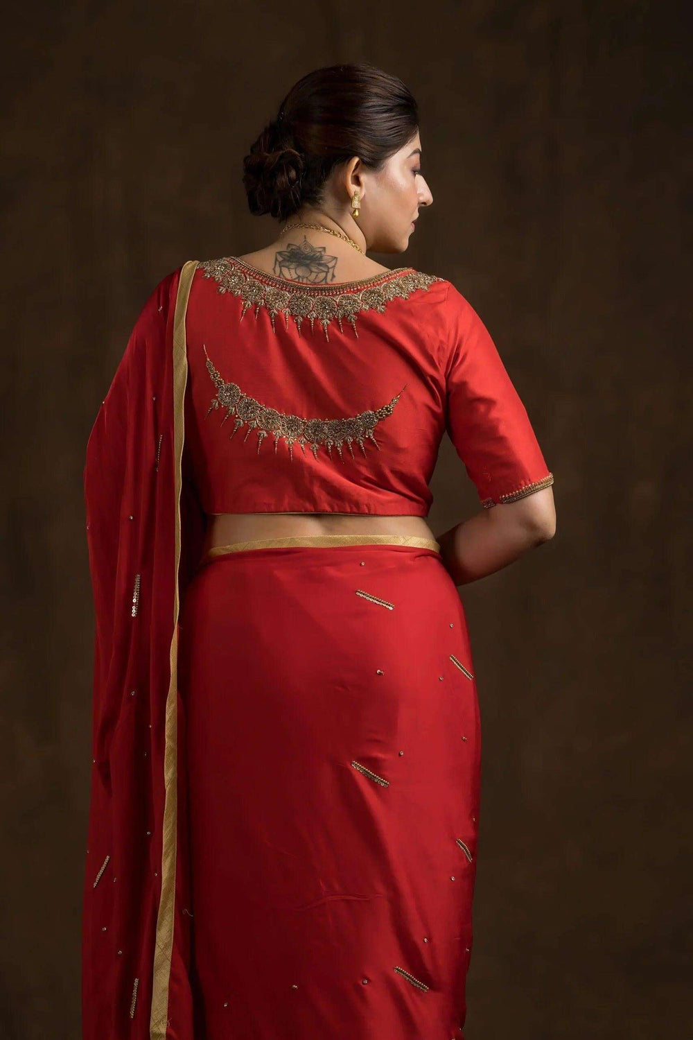 Gold chand embroidery and scalloped back neckline on the red blouse