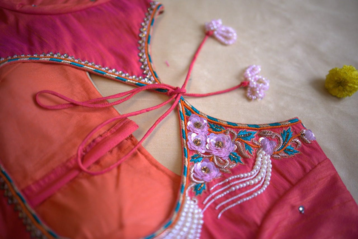Close-up of the neckline embroidery, lilac rosettes and pearl strands beside a tie-up dori