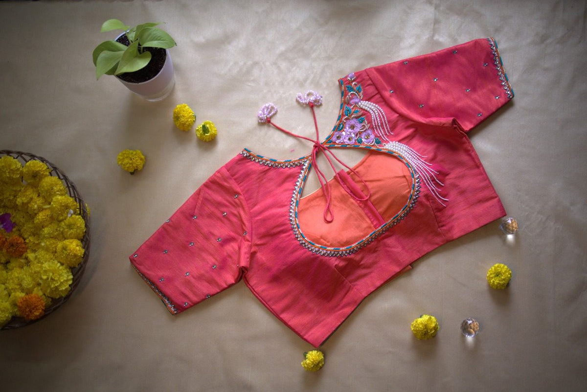 Back opening of the blouse showing coral lining, rosette embroidery framing the edge