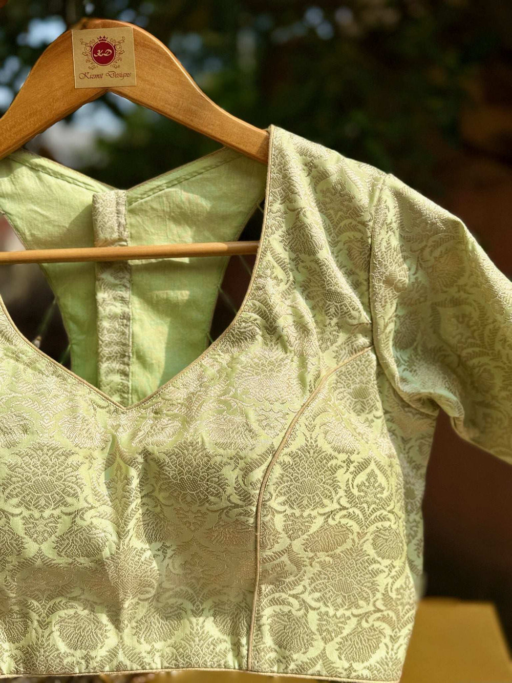Brocade blouse on a wooden hanger, sweetheart neckline and short sleeves in pistachio green