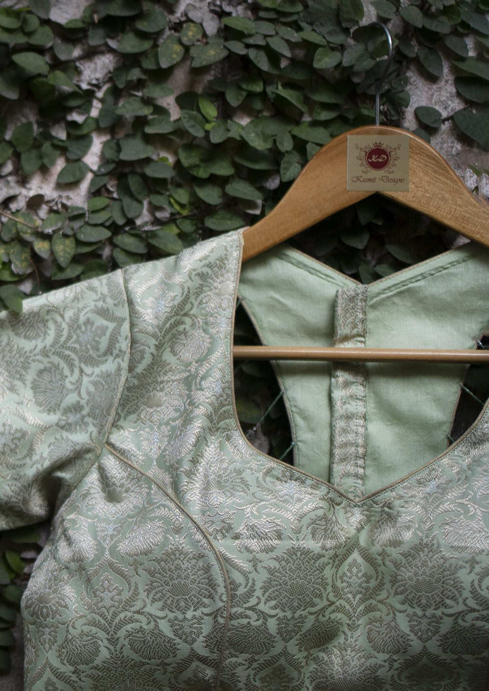 Back of the blouse with plain green yoke and covered button placket, brocade sleeve alongside