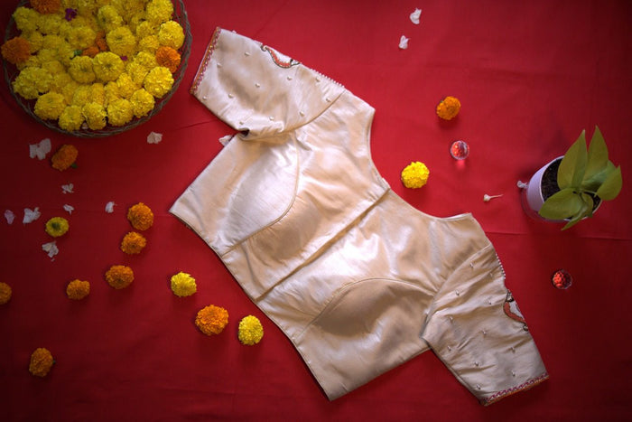 Blouse turned over on the red cloth, plain cream reverse with shaped seams