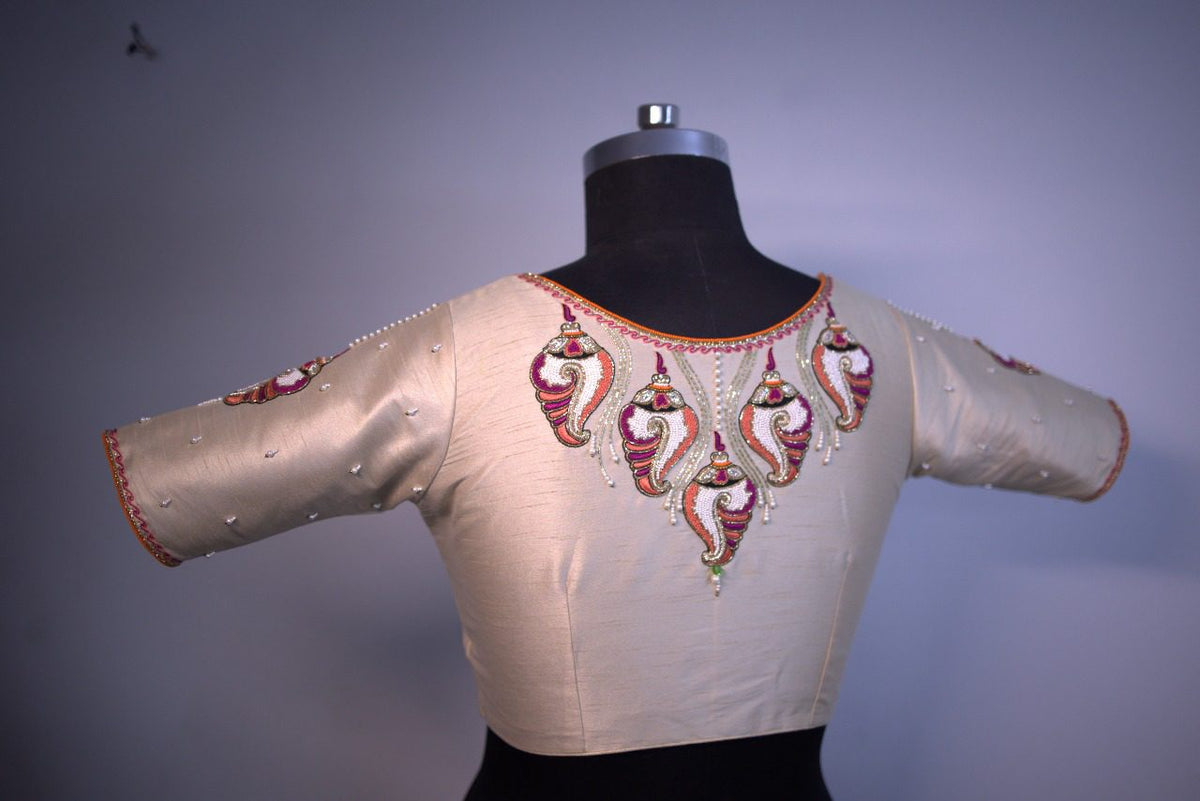 Blouse on a mannequin, back view with embroidered motifs across the yoke