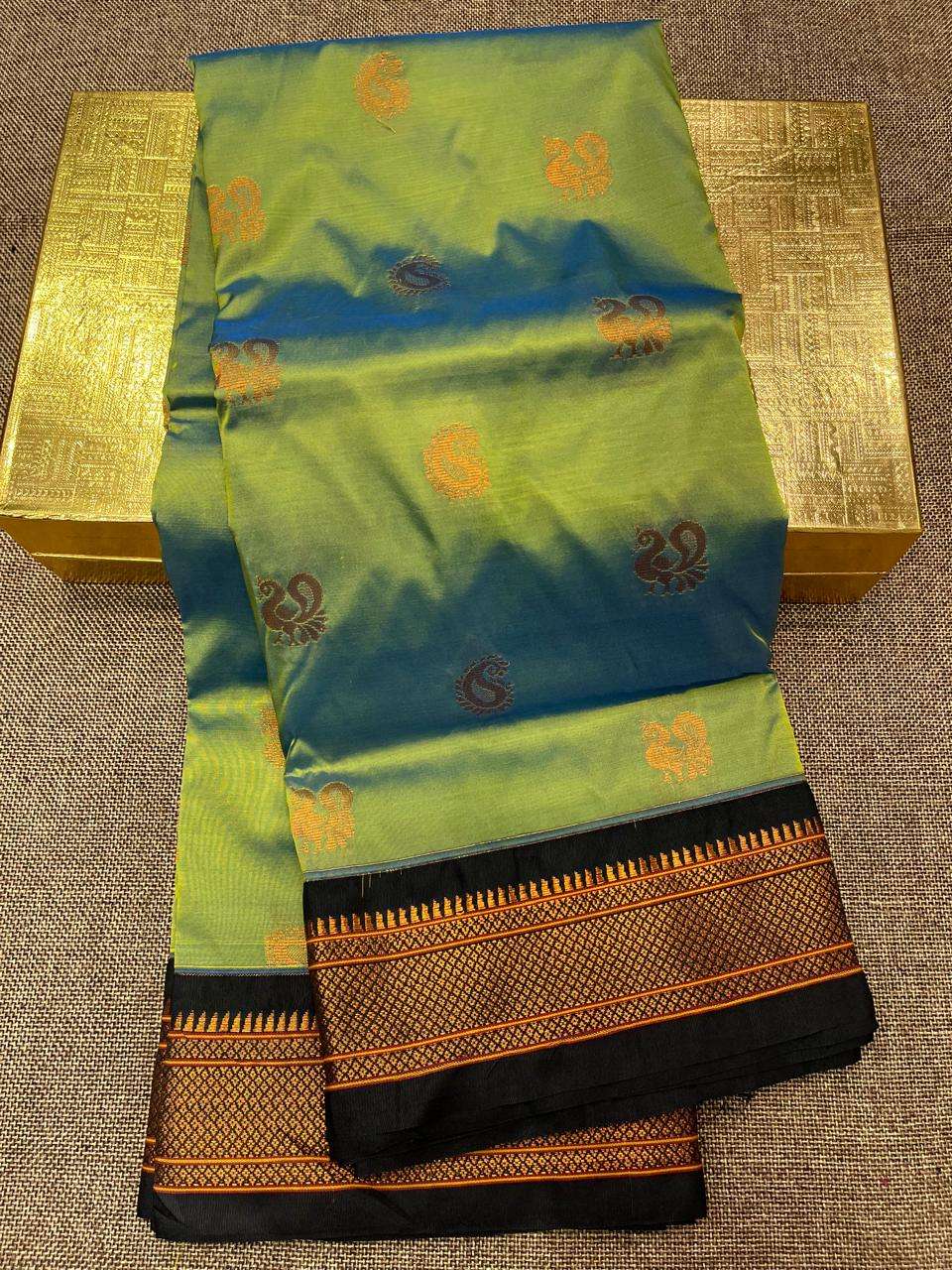 Green-blue shot Paithani saree folded flat, orange bootis and black temple border