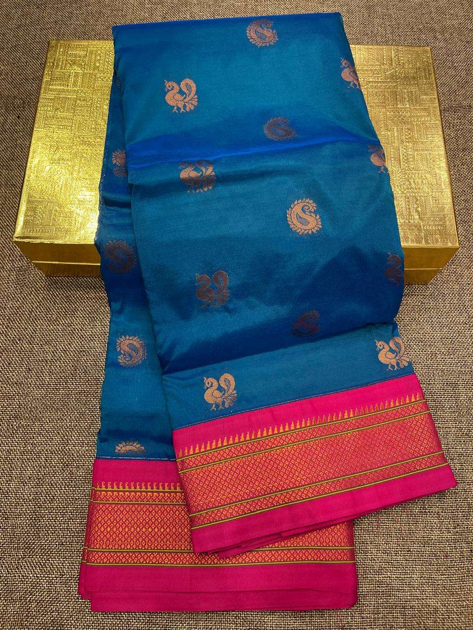 Peacock blue semi kadiyal saree on a gold box, rani pink border with temple edging