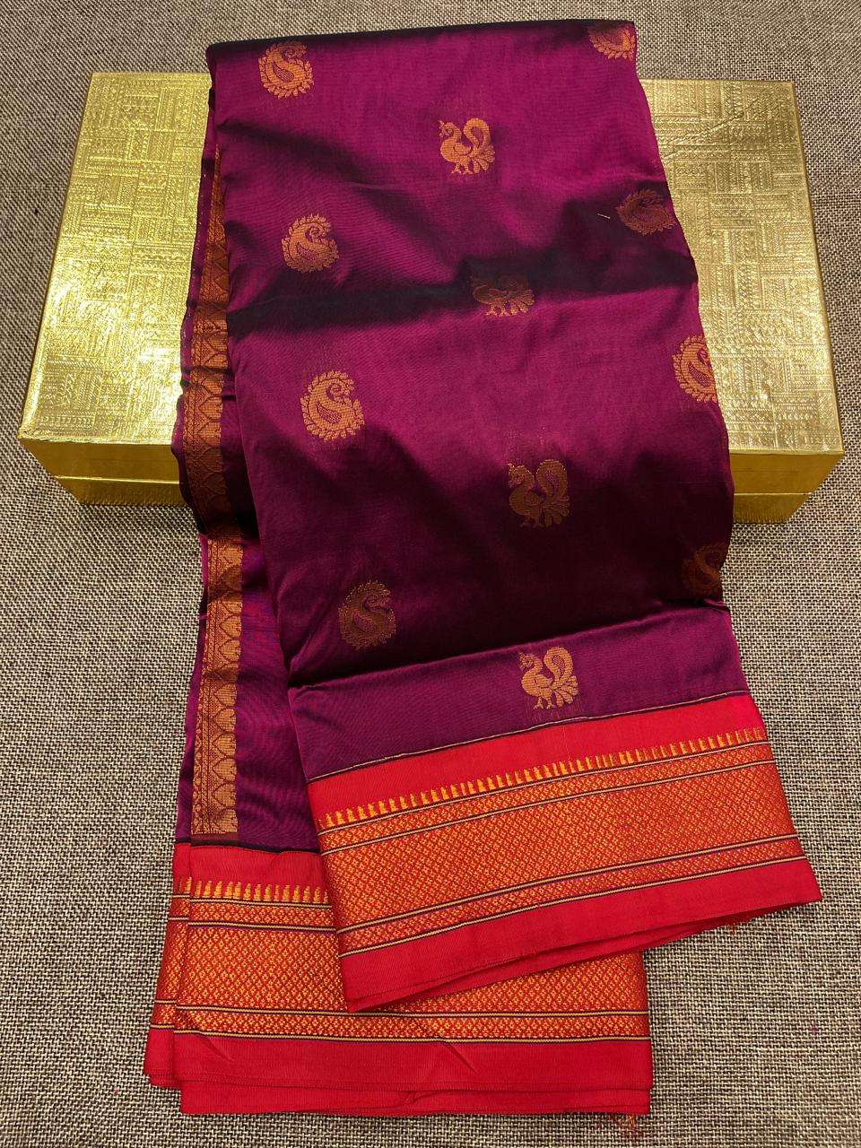 Wine purple saree body with copper bootis and a red temple-edged border, laid flat
