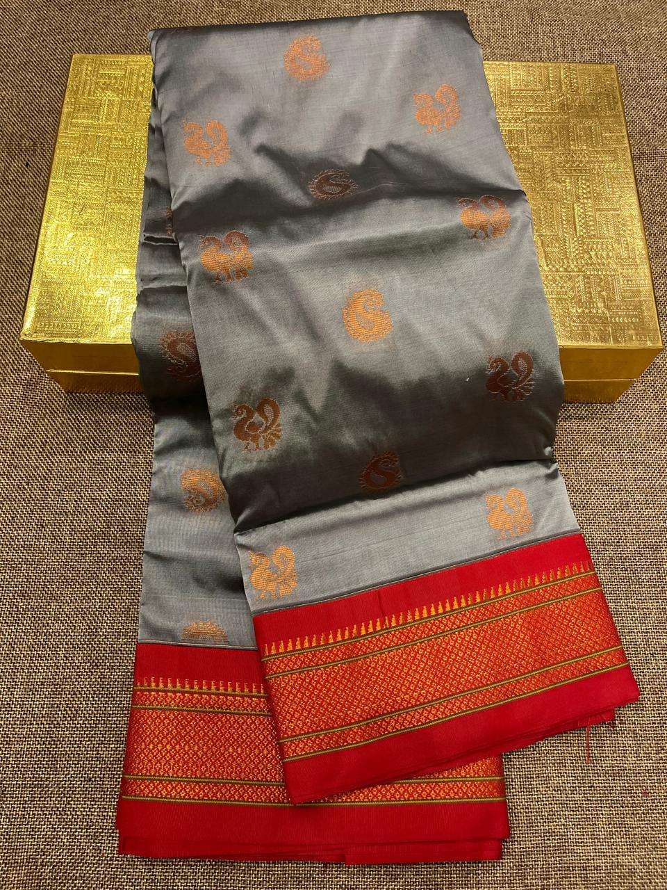 Grey semi Paithani saree, orange peacock bootis set against a red brocade border