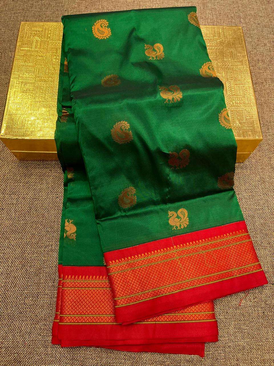 Bottle green kadiyal saree with gold peacock bootis and red temple border