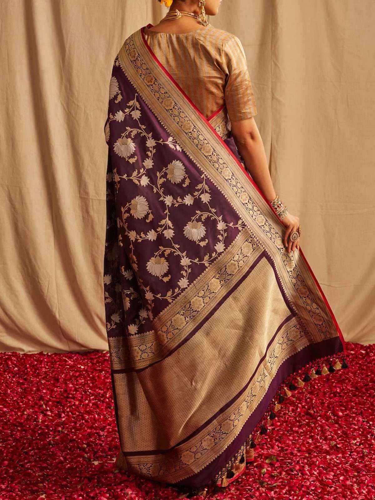Back view of the draped purple saree showing the gold zari pallu with tassels