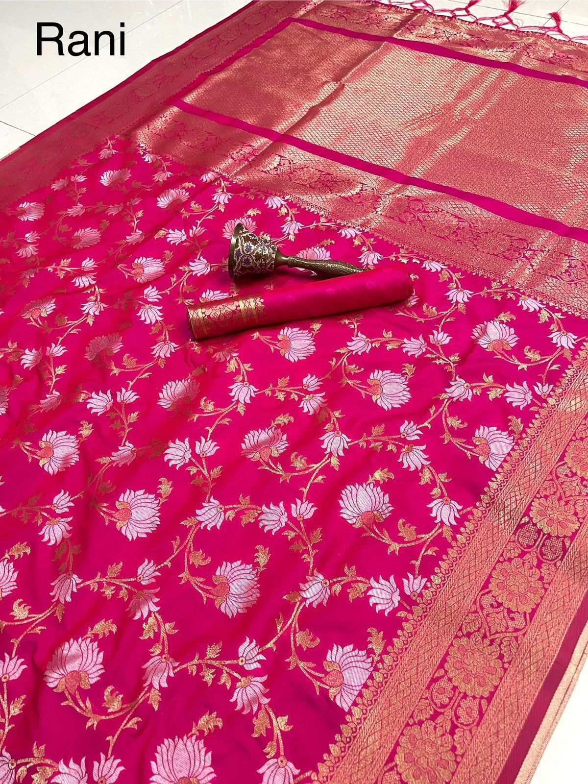 Rani pink saree flat lay with floral jaal and gold zari pallu, labelled Rani
