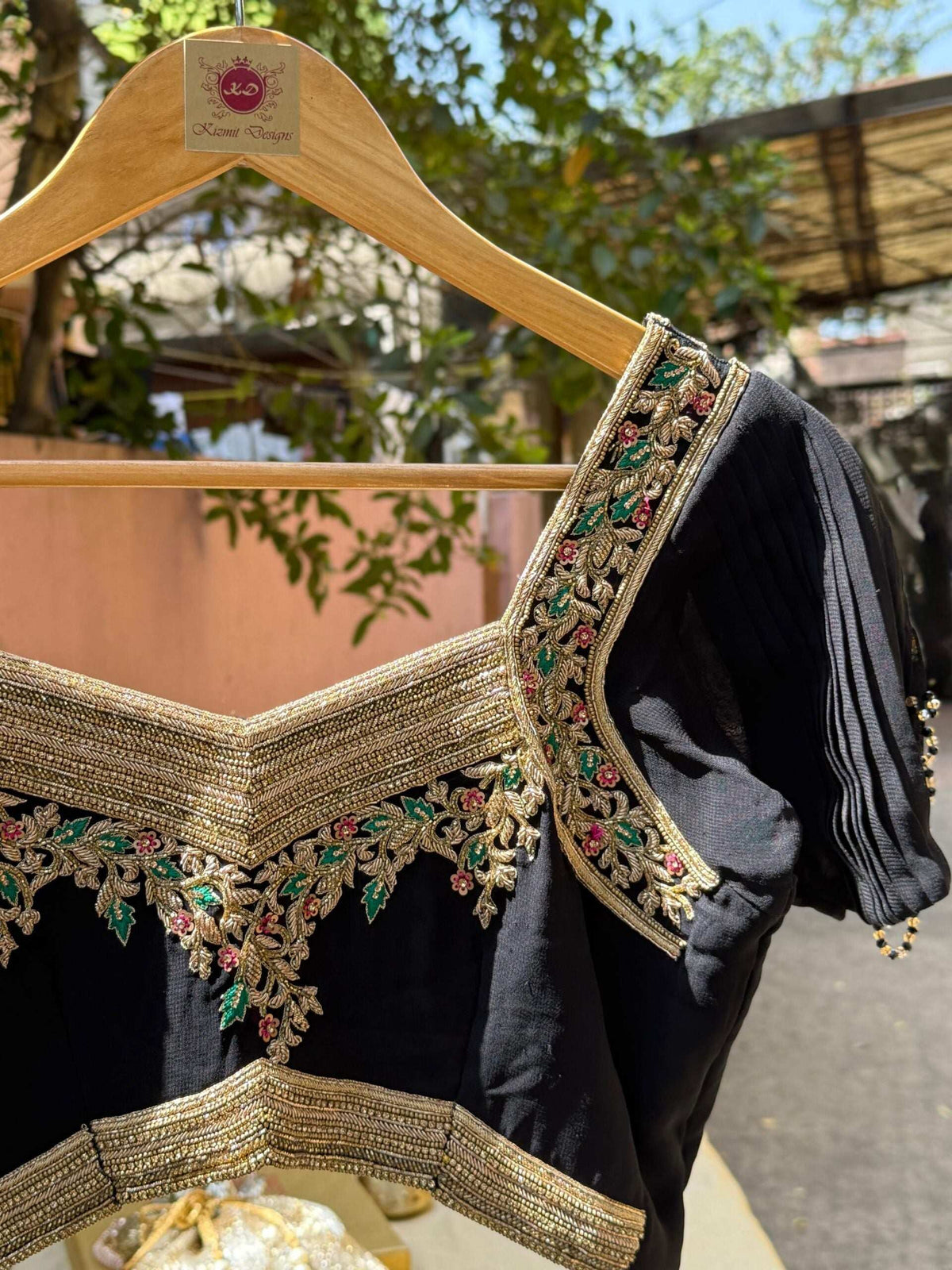 Side view on the hanger with beaded tassels along the puff sleeve hem