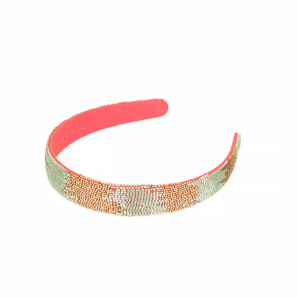 Angled view of the rays headband, beadwork curving over the coral covered base