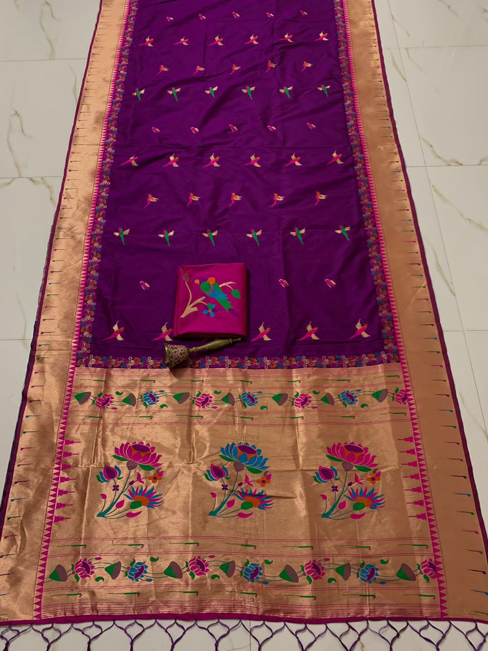 Violet body with muniya bootis and a wide gold zari lotus pallu