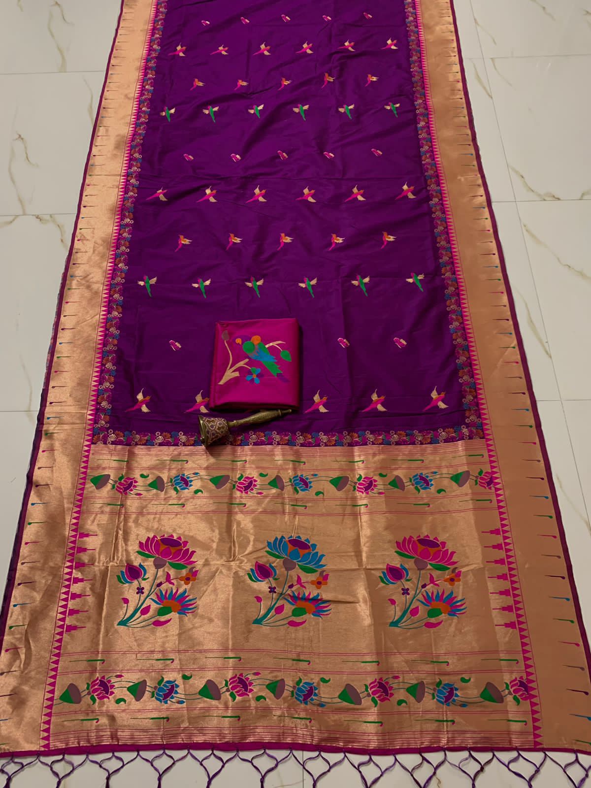 Violet body with muniya bootis and a wide gold zari lotus pallu
