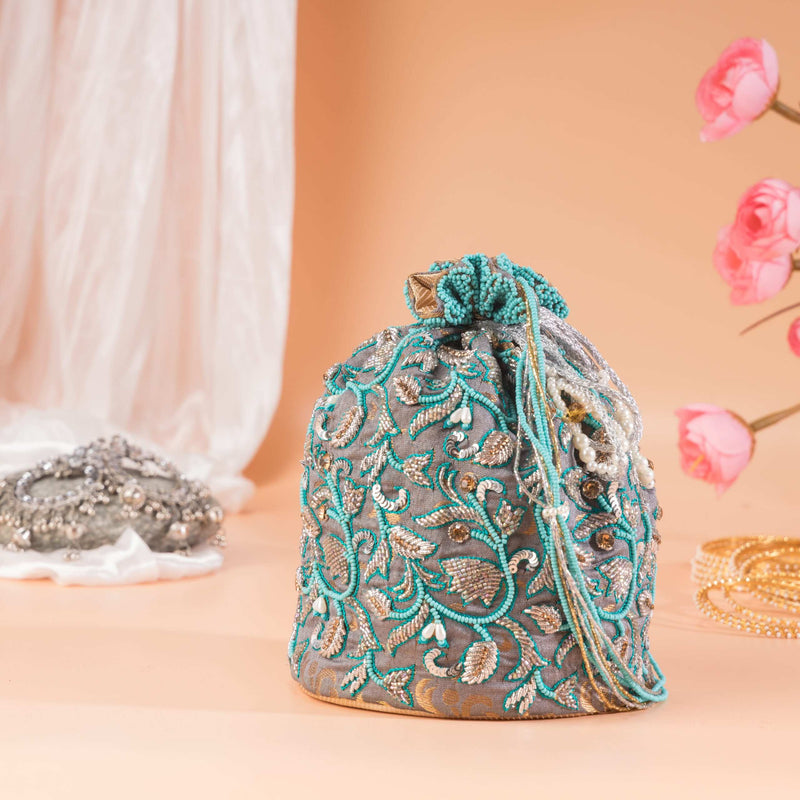 Grey potli bag with turquoise and silver floral vine beading, drawstring pulled closed